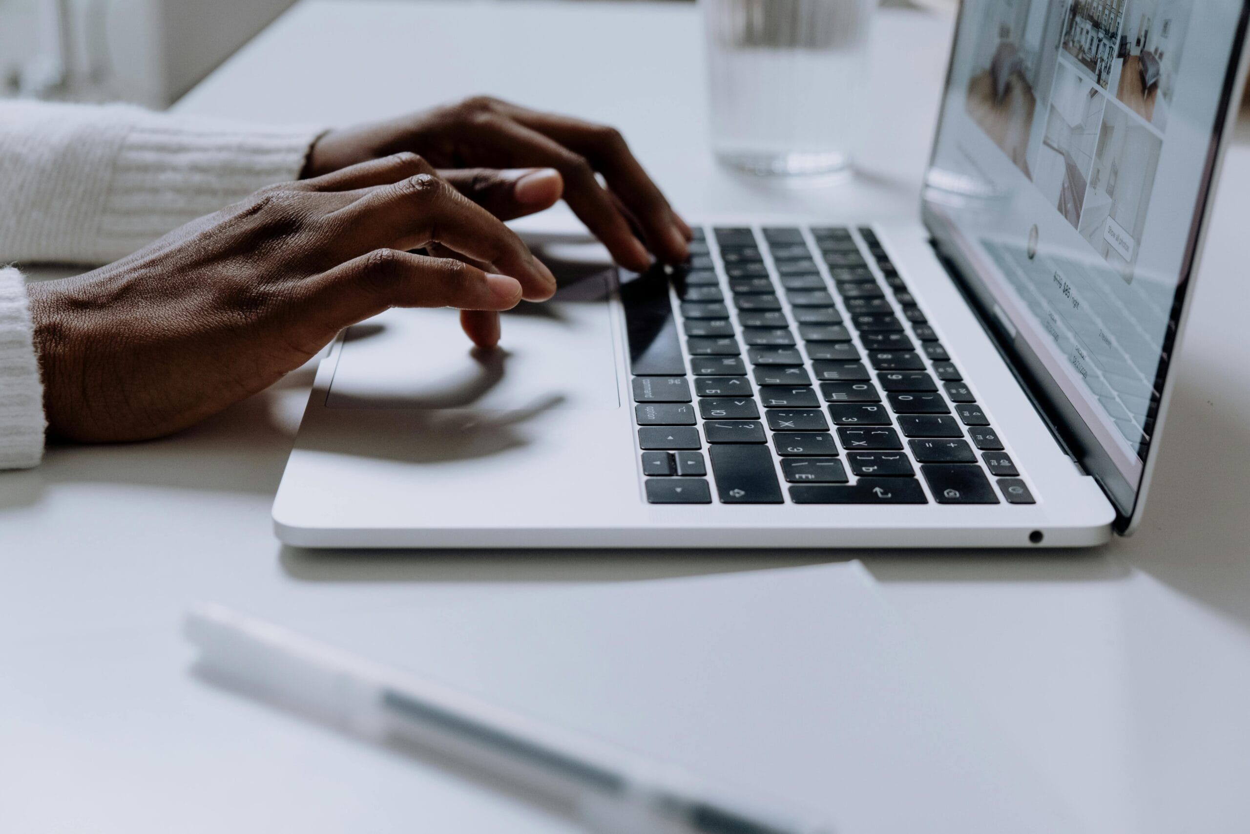 Hands typing on a sleek laptop keyboard, illustrating modern technology in use.